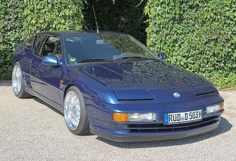 Blue Alpine A610 at a classic-car show, three-quarter front view