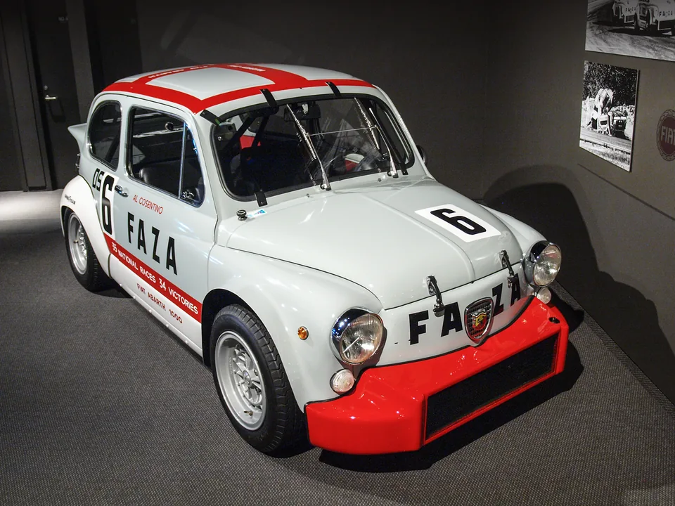 White and red Fiat-Abarth 1000 TCR touring-car racer, front three-quarter view, museum display