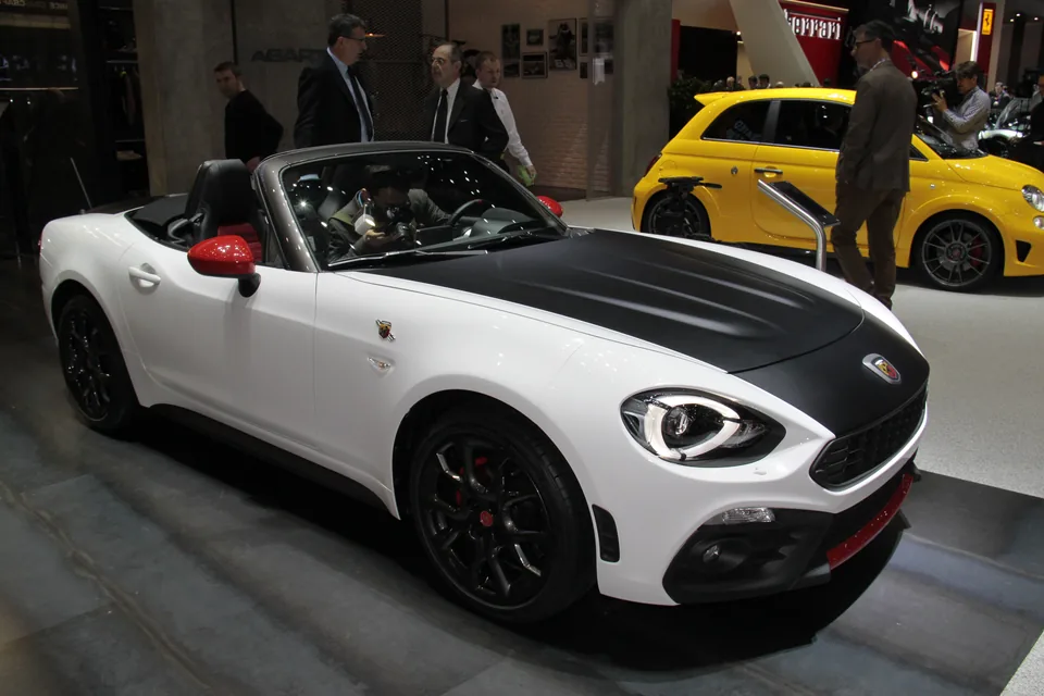 White Abarth 124 Spider with black bonnet, front three-quarter view, indoor auto show