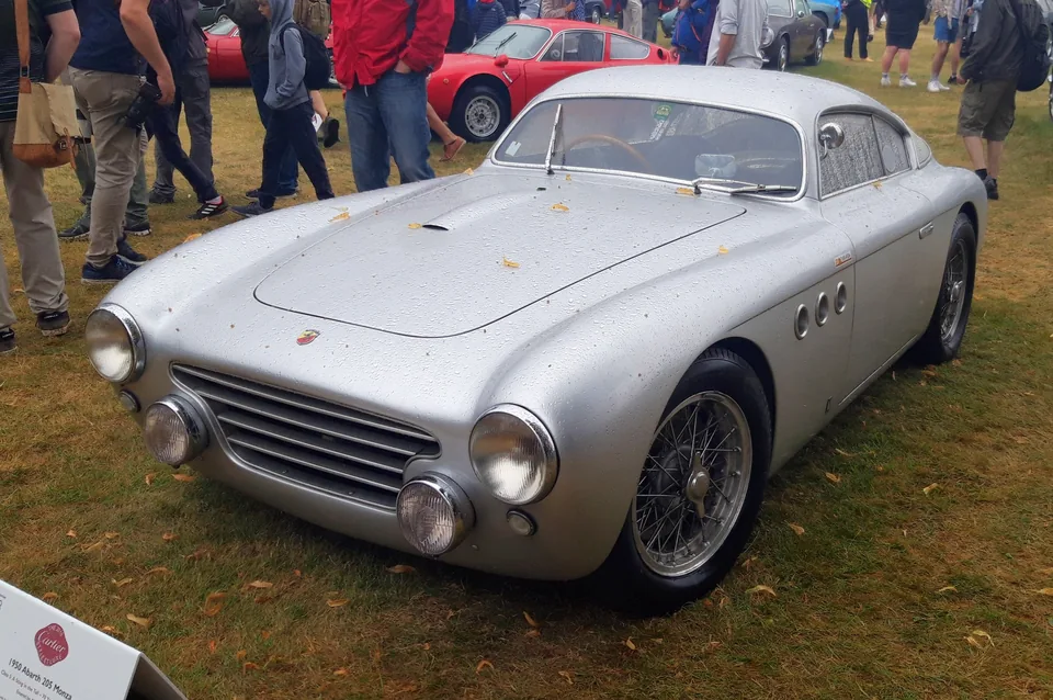 Silver unpainted-aluminum Abarth 205A Berlinetta, front three-quarter view, outdoor car show