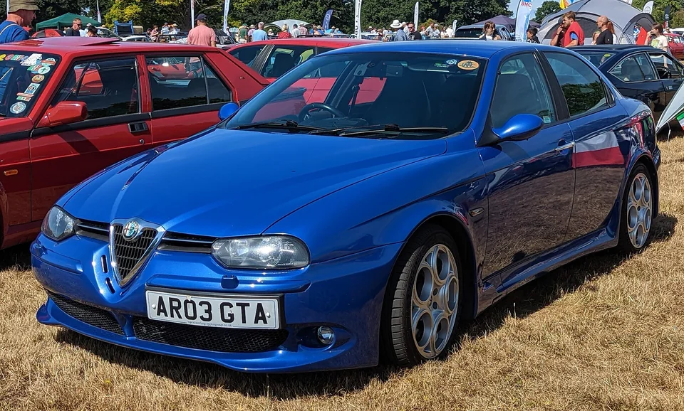 Blue Alfa Romeo 156 GTA saloon, front three-quarter view on grass