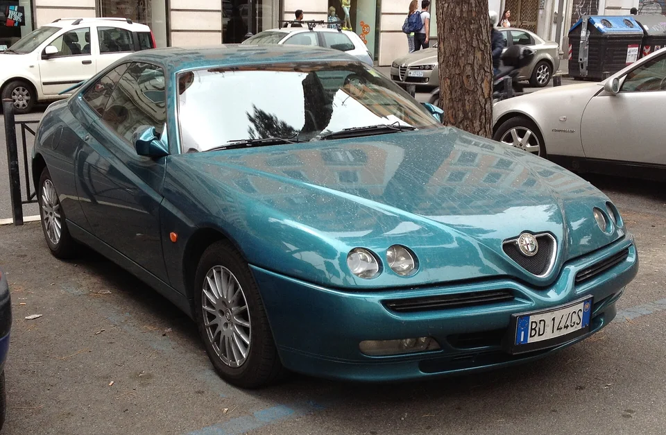 Teal Alfa Romeo GTV (916), front three-quarter view parked on a street