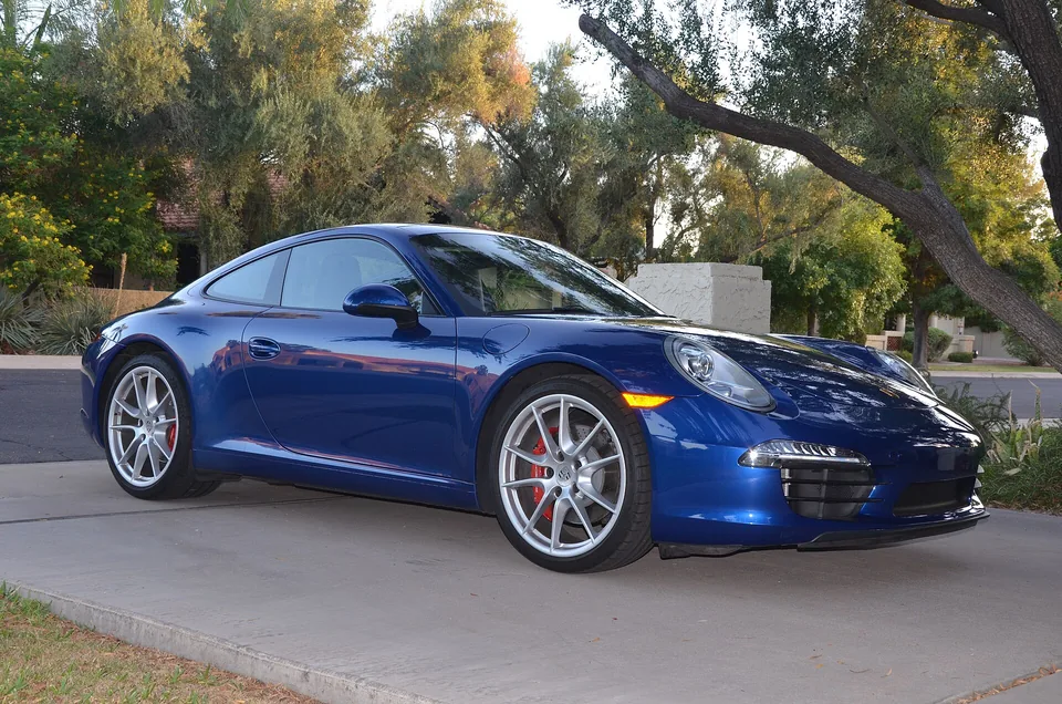 Aqua Blue Metallic Porsche 911 Carrera S (991.1) coupé on an Arizona driveway, three-quarter front view