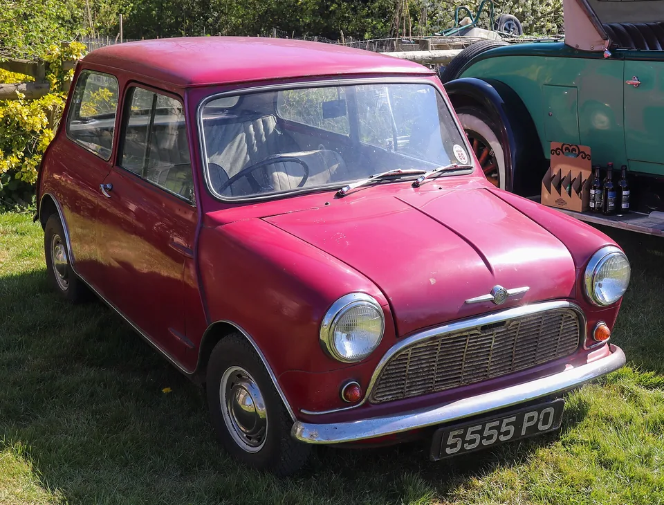 Maroon 1959 Morris Mini-Minor on grass at a classic show, three-quarter front view