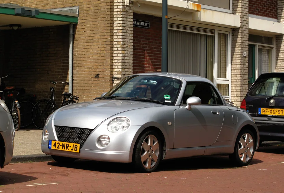 Silver Daihatsu Copen (L880K) with the hardtop raised, three-quarter front view