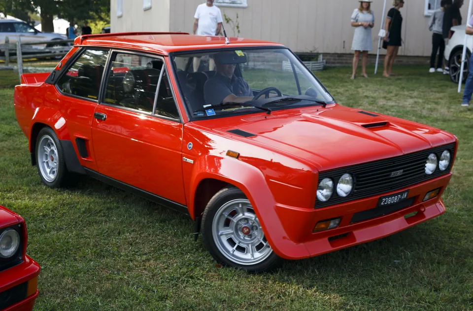 Red Fiat 131 Abarth Rally Stradale, front three-quarter view, outdoor car show