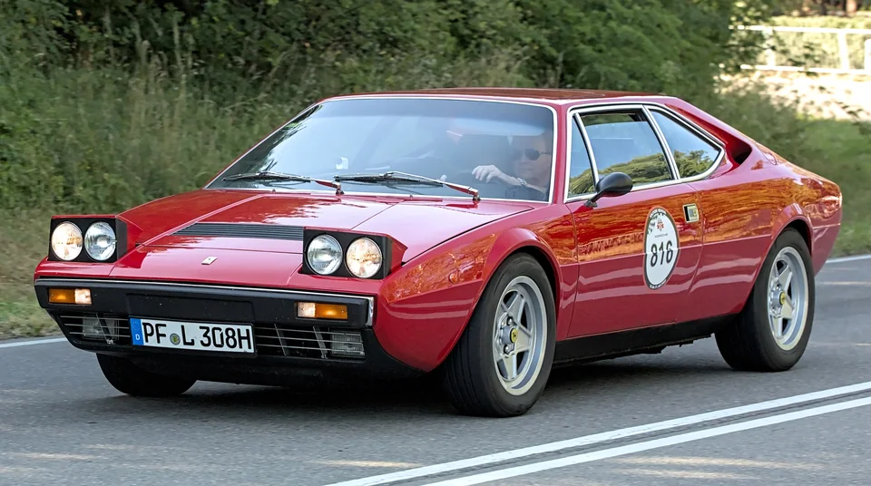 Red Ferrari Dino 308 GT4 on a country road, three-quarter front view