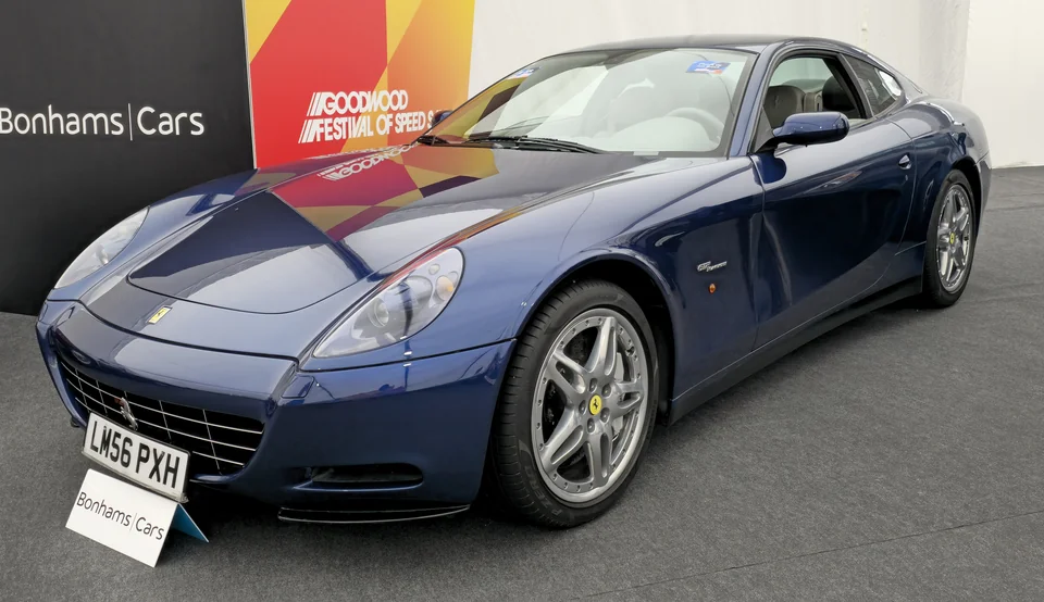 Dark blue Ferrari 612 Scaglietti at a Goodwood auction stand, three-quarter front view