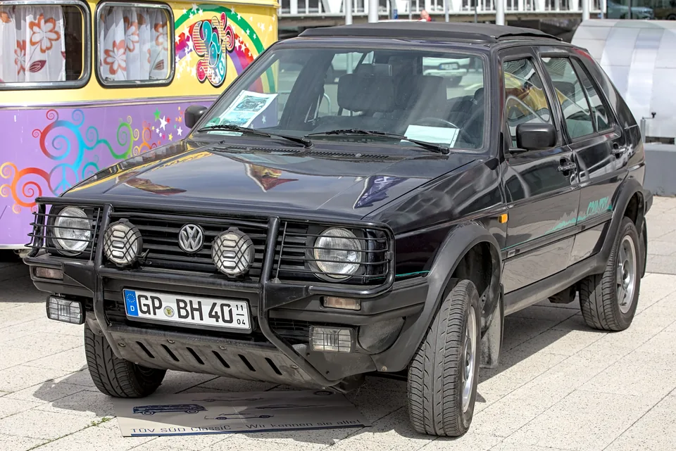 Black Volkswagen Golf Country with tubular bull bar and rear-mounted spare wheel, three-quarter front view