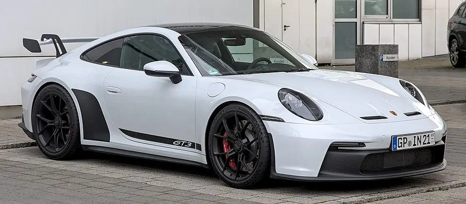 White Porsche 911 GT3 (992) with fixed rear wing, three-quarter front view