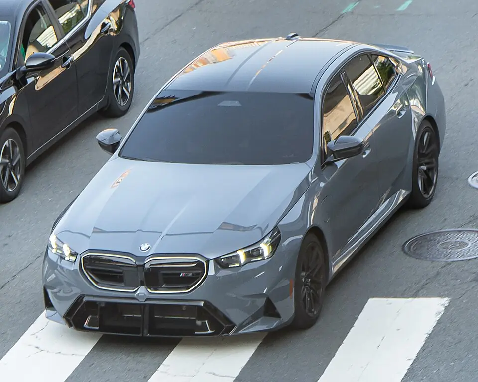 Grey BMW M5 (G90), three-quarter front view