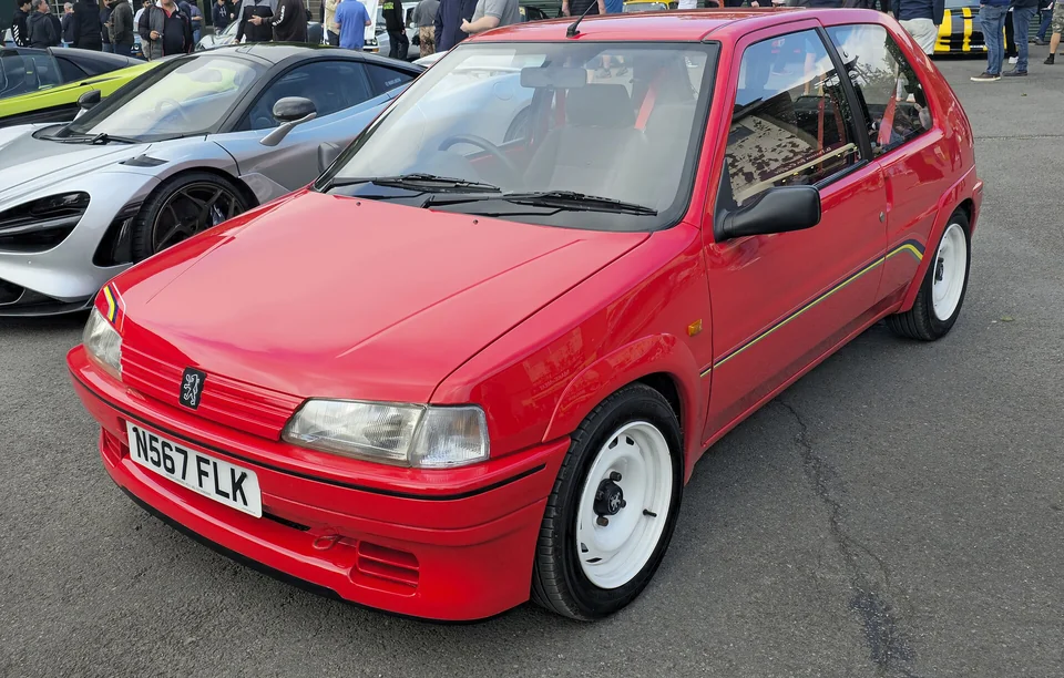 Red Peugeot 106 Rallye with white steel wheels, front three-quarter view