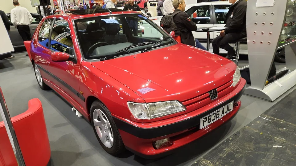 Red Peugeot 306 GTi-6, front three-quarter view at an indoor motor show