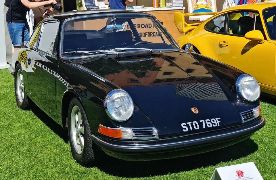 Black 1967 Porsche 911 S 2.0 coupé on Fuchs wheels with chrome bumpers on the lawn at the London Concours, three-quarter front view