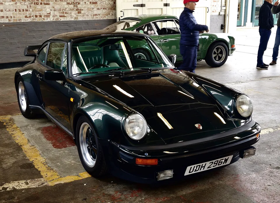 Dark green Porsche 911 Turbo (930) with whale-tail spoiler, three-quarter front view