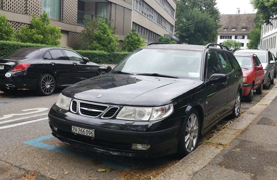 Black Saab 9-5 Aero SportCombi parked on a Zurich street, three-quarter front view
