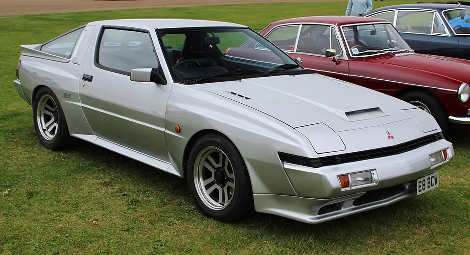 Silver Mitsubishi Starion EX Turbo wide body, front three-quarter view on grass