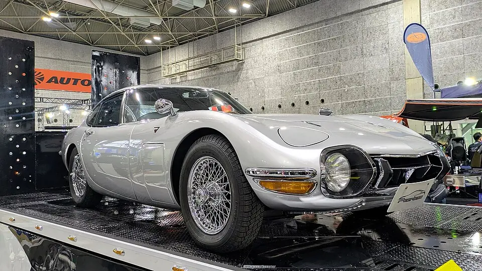 Silver Toyota 2000GT, front three-quarter view, indoor auto show