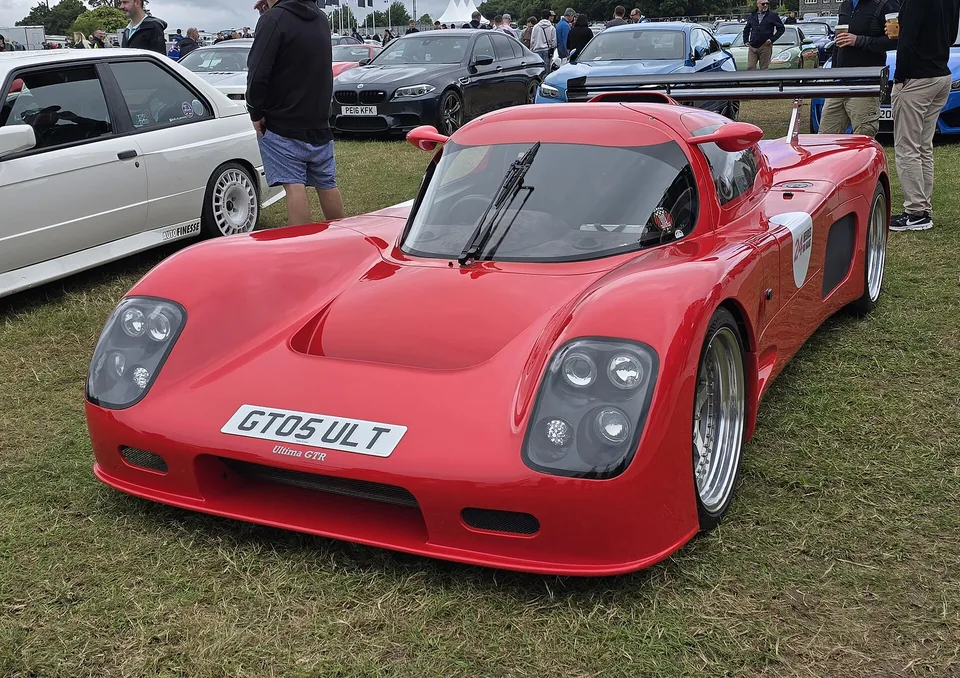 Red Ultima GTR at a motoring event, three-quarter front view