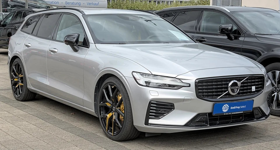 Silver Volvo V60 Polestar Engineered on a German dealer forecourt, three-quarter front view showing the gold Brembo calipers