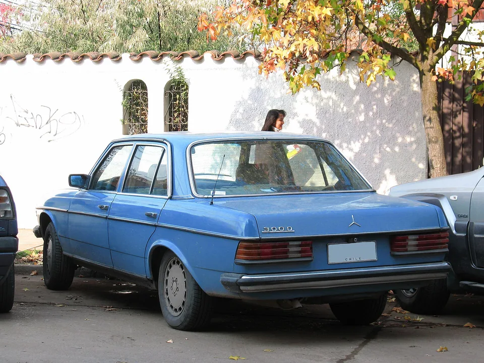 Blue Mercedes-Benz 300 D (W123) parked on a street in Chile, rear three-quarter view with the 300 D bootlid badge